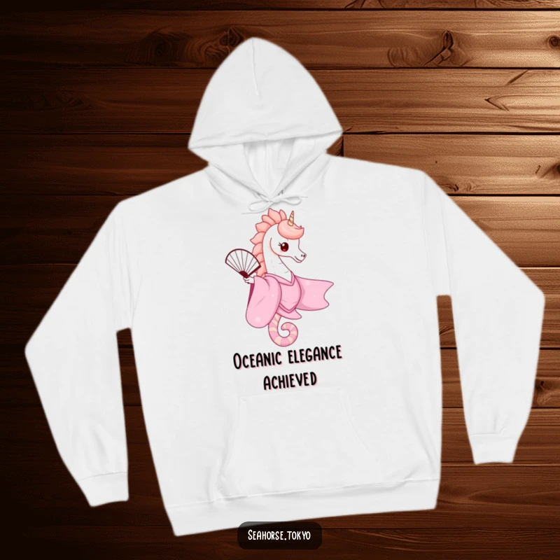 A cozy hoodie showcasing a cute seahorse in a flowing pink kimono, gracefully balancing a fan, perfect for warm and stylish comfort.